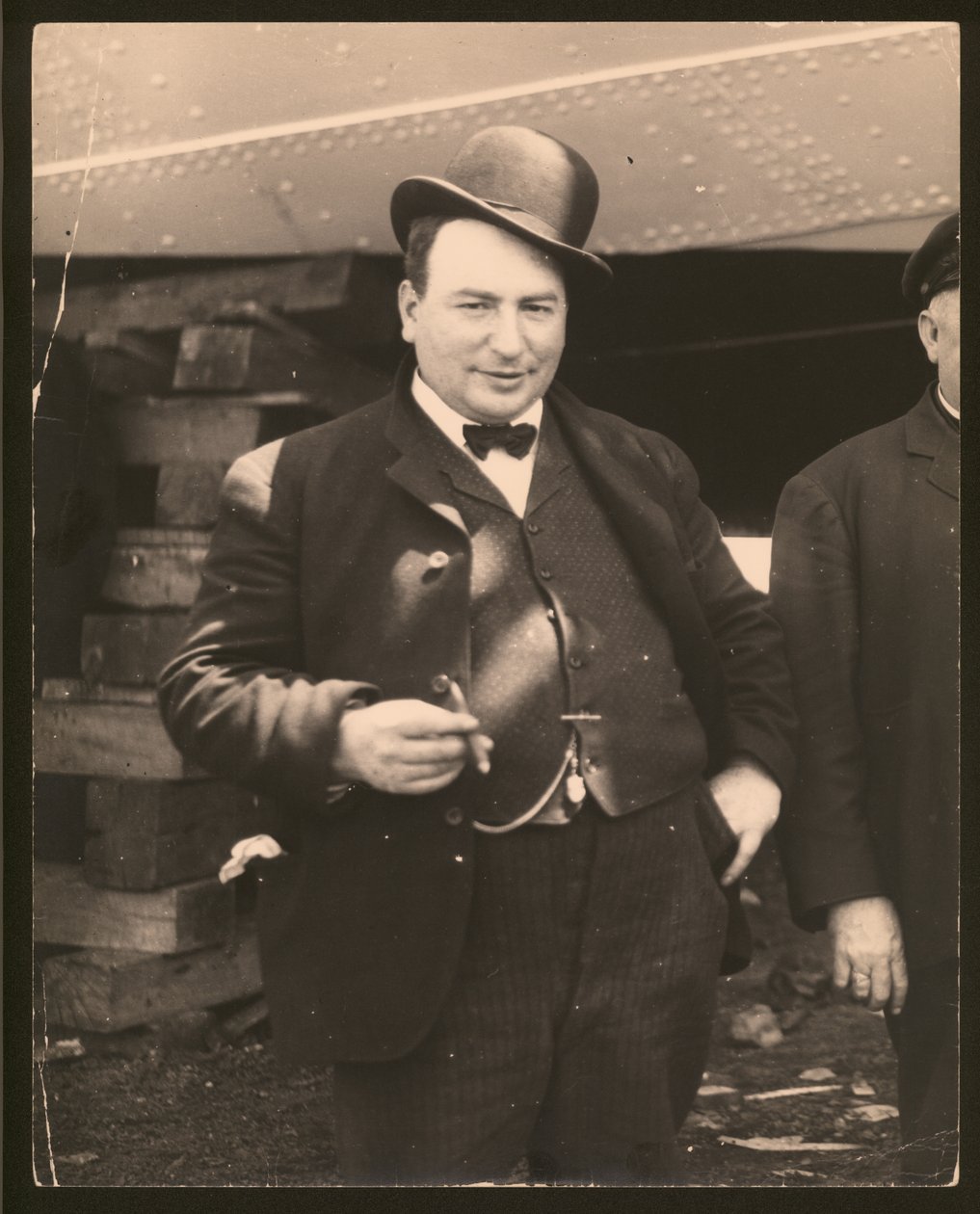 Derbi şapkalı ve papyonlu bir adamın puro içtiği dikey, siyah beyaz fotoğraf by William G. Swekosky