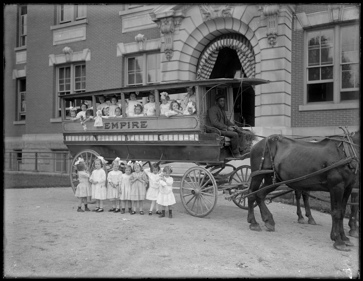Küçük kızlar atlı bir vagonun içinde ve önünde, kimliği belirsiz bir binanın önünde poz veriyor, muhtemelen Roma Katolik Yetimhanesi, Kingsbridge, Bronx, 1910 dolayları by William Davis Hassler