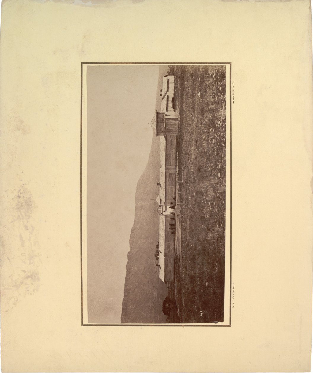 Giriş kapısında toplanmış birkaç adamla dolu bir barakanın görünümü, 1871 (sepya fotoğrafı) by William Hicks Jackson