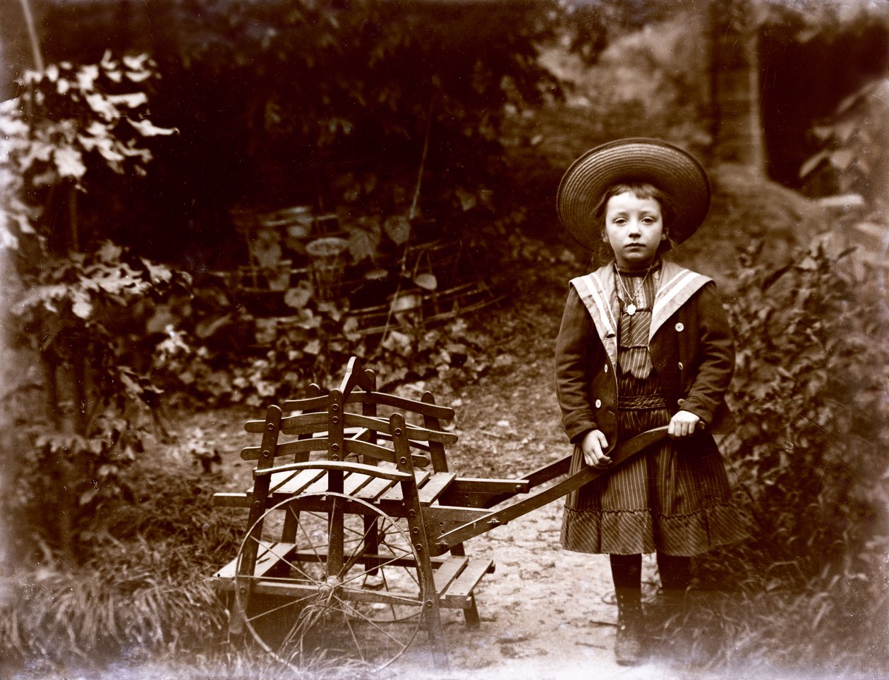 Bahçede arabası olan kız, yirminci yüzyılın başlarında (s/b fotoğraf) by . .
