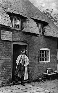 Bir dükkanın önünde pipo içen bir adam, Worcestershire, c1922. by A. W. Cutler
