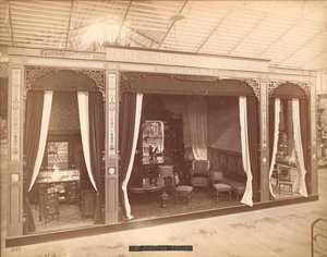 James Shoolbred & Co.'nun sergisi -- Ana Bina, Mobilyalı üç oda. Soldaki odada üç dolap, lavabo, ibrik ve ayna; merkez odada bir masa, sandalyeler, bir kanepe ve aynalı ve heykelli bir büfe; T