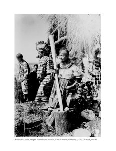 Annie Jumper Tommie havan ve havaneli kullanarak mısır unu ve oğlu Tony Tommie, kartal tüyü bir bone takmış, 5 Şubat 1927