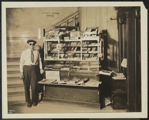 Kör haber satıcısı John Martie, New York Belediye Binasının güney ucundaki standında by Company Byron