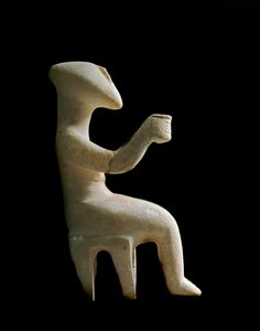 Kiklad Sanatı: “” Bir taburede oturan heykelcik””” Koyu sarı ile işlemeli mermer idol. Kiklad uygarlığı (-3200 a -2000) Güneş. 15,2 cm Atina, Ulusal Arkeoloji Müzesi (inv. 3910)