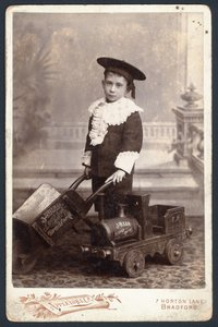 Bir oyuncak tren ve el arabası olan çocuk by English Photographer