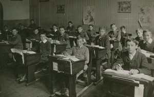 Okulda bir ders sırasında sıralarının arkasında oturan erkek öğrenciler by English Photographer
