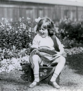Genç bir kız Betty, deri bir sandıkta otururken bir Doğu İndigo Yılanı tutuyor, Londra Hayvanat Bahçesi, 1924 by Frederick William Bond
