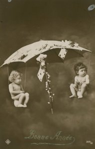 1913 yılında gönderilen bir şemsiyeden sarkan iki bebek ile Mutlu Yıllar kartı by French Photographer