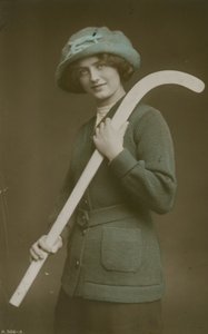 Omzunda bir hokey sopası taşıyan genç bir kadının 1913