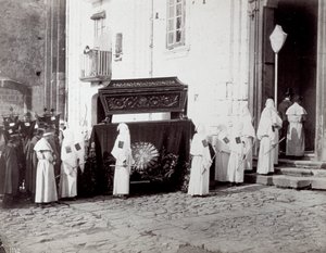 Napoli'deki San Francesco Cemaati'nin cenaze töreni. Ön planda, bir kilisenin önünde, beyaz tunikli ve kapüşonlu çok sayıda 'kardeş kardeş', üzerine tabutun yerleştirildiği işlemeli bir bezle süslenmiş bir katafalka eşlik ediyor. by Giorgio Sommer