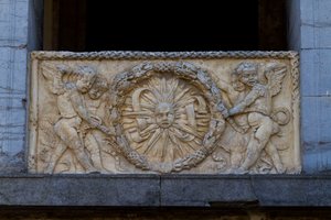 Çelenk içinde ışınlı güneş ile korkuluk plakası, San Sebastiano kilisesinin cephesinde kısma