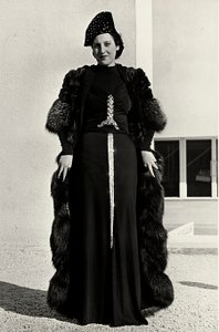 İtalyan moda evi "Dragoni" tarafından yaratılan gece elbisesi modeli. Yazının yazı tipi, kılıç şeklinde gösterişli payetli bir bezemeye sahiptir. Bir şapka ve kürk palto, topluluğu tamamlıyor. (s/b fotoğraf)