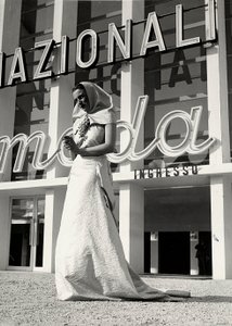 "Lamma" moda evi tarafından yaratılan gelinlik modeli. Eşya, bir salkım üzüm şeklinde gösterişli bir iğne ile boyunda tutulan manastır tarzı bir başlık ile karakterizedir. (s/b fotoğraf) by Luis Bogino