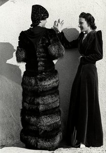 İki model, İtalyan moda evi "Dragoni"nin kreasyonlarını sunuyor. Arkadan görülen bir model gümüş bir tilki ceketi giyiyor. Diğer model ise uzun kadife bir palto giyiyor. (s/b fotoğraf)