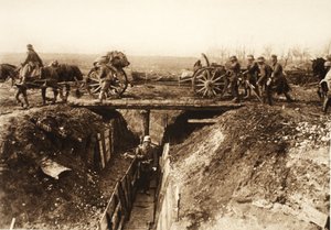 Tarla topçuları, saldırıya uğramış bir düşman siperinin üzerinden geçer; düşman mevzilerinin üstesinden gelmek için silah vagonuna bağlanan büyüleyici demetler (s/b fotoğraf) by Photographer German