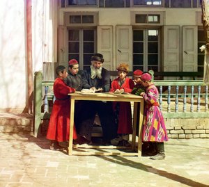 1905 ve 1915 yılları arasında Semerkant, Rusya İmparatorluğu'nda bir evin önündeki masada öğretmeni olan bir grup Yahudi çocuk