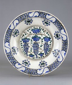 Ortasında üç salkım üzüm ve asma yaprağının betimlendiği yuvarlak bir İznik çanak çömlek, 1570 dolayları (seramik) by Turkish School