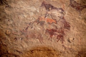 Kaya sanatı, Tarih Öncesi: Sudan, Uweinat masifinde süslü bir barınakta bir grup sığır ve çok renkli karakterin (çobanlar ve okçular) kaya resmi. MÖ 8000 ila 3000 yıl arası dönem. fotoğrafçılık by Unbekannt