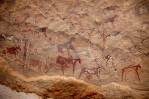 Kaya sanatı, Tarih Öncesi: Sudan, Uweinat masifinde süslü bir barınakta bir grup sığır ve çok renkli karakterin (çobanlar ve okçular) kaya resmi. MÖ 8000 ila 3000 yıl arası dönem. fotoğrafçılık by Unbekannt