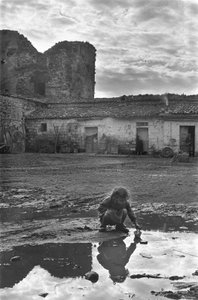 Çamurla çevrili bir su birikintisinde kağıt tekneyle oynayan genç kız, Venosa, Basilicata, İtalya by Unbekannt