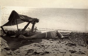 Bir havlunun gölgesinde deniz kıyısında uzanmış iki kadın. Fotoğrafçı tarafından Vincenzo Balocchi