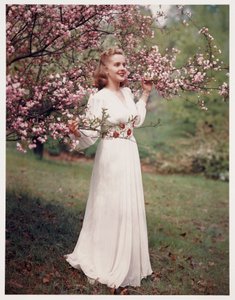 Çiçeğin yakınında bir elbise modelleyen kadın, 1940