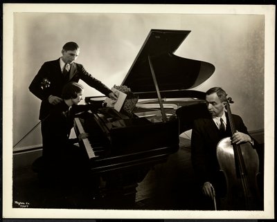 Kör kadın, Bayan Harding, piyano başında iki kör adama keman ve çello öğretiyor, 1936 (gümüş jelatin baskı) by Byron Company