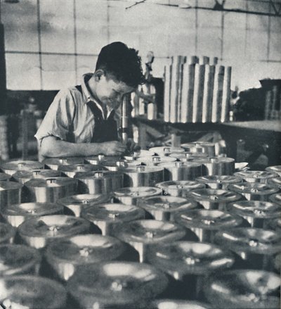 Pistonların sertliğini mikroskopla test eden çırak, 1941 by Cecil Beaton