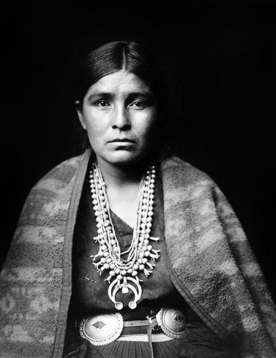 Navajo kadını, gümüş kabak çiçeği kolye, konko kemer, omuzlarına bol dökümlü battaniye, c. 1904, fotoğraf Edward S. Curtis by Edward Sheriff Curtis