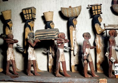 Mısır antikası: Ölen kişiye adak sunan hizmetçileri temsil eden yontulmuş bir boyalı ahşap grubu. Kahire, Mısır Müzesi by Egyptian Egyptian