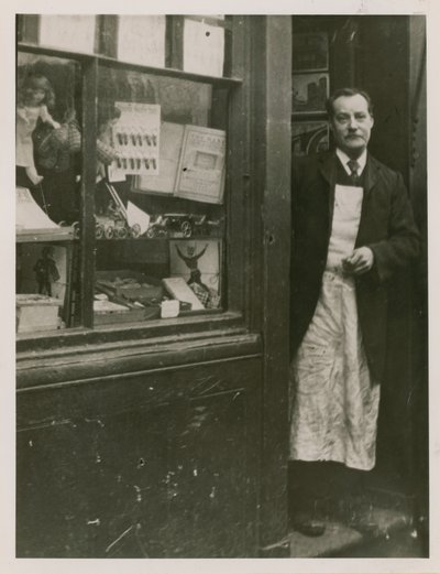 Dükkanının kapısında duran bir dükkan sahibi by English Photographer