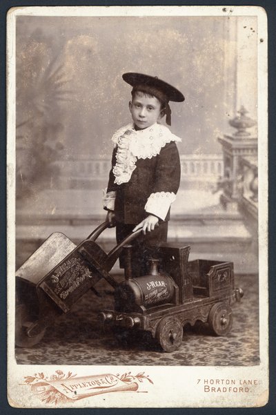 Bir oyuncak tren ve el arabası olan çocuk by English Photographer