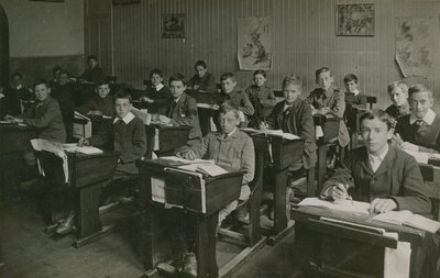 Okulda bir ders sırasında sıralarının arkasında oturan erkek öğrenciler by English Photographer