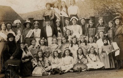 Dünya kostümleri giymiş öğretmenleriyle birlikte bir grup kız öğrenci portresi (s/b fotoğraf) by English Photographer