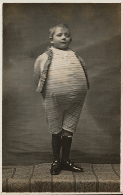 Okul çocuğu, çok büyük bir mideye sahip olacak şekilde giyinmiş (s/b fotoğraf) by English Photographer