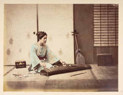 Şarkı söyleyen kızlar [Japonya], Yaylı bir enstrüman çalan bir tatami mindere oturmuş genç bir Japon kadının stüdyo portresi,  Fotoğrafçı: Bilinmiyor  Lucas Koleksiyonu: Charles James ve Morton P, Lucas