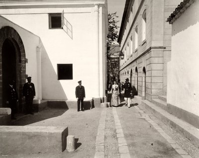 Üniformalı erkekler, zarif giyimli bir kadına eşlik eden Lo Zucco çiftliğinin kilisesine doğru eşlik ediyor, Sicilya, 1900 by Eugenio Interguglielmi