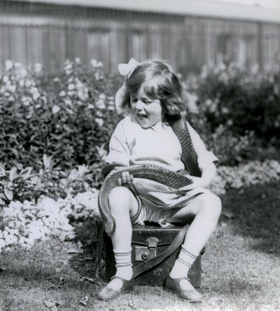 Genç bir kız Betty, deri bir sandıkta otururken bir Doğu İndigo Yılanı tutuyor, Londra Hayvanat Bahçesi, 1924 by Frederick William Bond