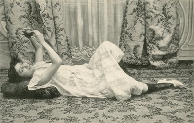 Kız, yerde yatarken, başının üstünde bir top tutuyor (s/b fotoğraf) by French Photographer