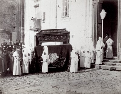 Napoli'deki San Francesco Cemaati'nin cenaze töreni. Ön planda, bir kilisenin önünde, beyaz tunikli ve kapüşonlu çok sayıda 'kardeş kardeş', üzerine tabutun yerleştirildiği işlemeli bir bezle süslenmiş bir katafalka eşlik ediyor. by Giorgio Sommer