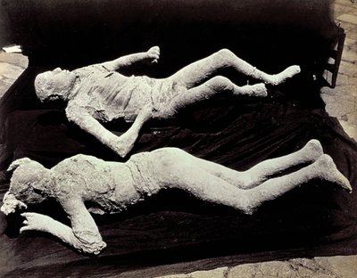 Pompeii kazılarından iki kalıp insan figürü. Sergiler, fotoğraflarını çekmek için siyah kumaş üzerine yerleştirildi. by Giorgio Sommer