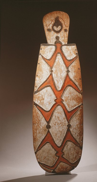 Oval Asmat kalkan, kabartma olarak oyulmuş, stilize figürler, üstte bir maske (ahşap) by Guinean New