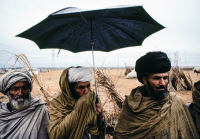 Şemsiyeli ve geleneksel giysili Pakistanlı erkekler by James L Stanfield