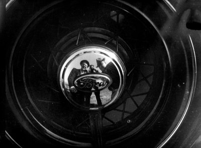 Bazı insanlar kendilerini bir Ford jant kapağının içinde yansıtırlar. by Luigi Leoni