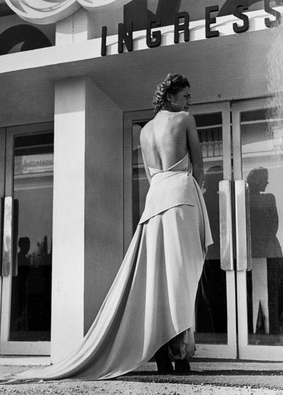 Moda evi "Graldi" tarafından yaratılmış bir gece elbisesi giyen modelin arkadan görünüşü. Makale, çıplak bir sırt ve tren ile karakterizedir. (s/b fotoğraf) by Luis Bogino
