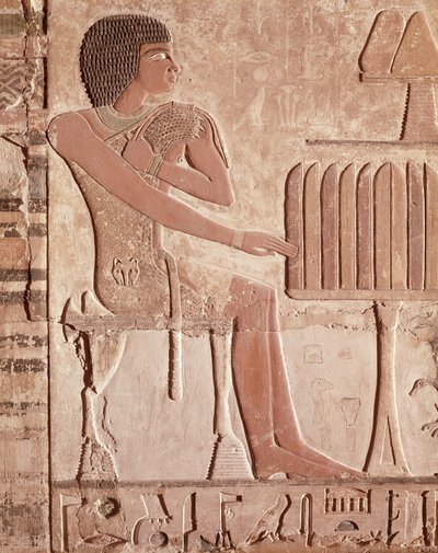 Ölünün ekmekle birlikte bir sunu masasının önünde oturduğunu gösteren kabartma (boyalı taş) by Old Kingdom Egyptian
