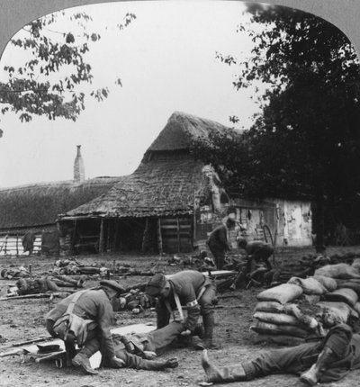 Doğaçlama bir ilk yardım direğinde yaralılara bakan sedye taşıyıcıları, I. Dünya Savaşı, c1914-c1918. by Realistic Travels Publishers