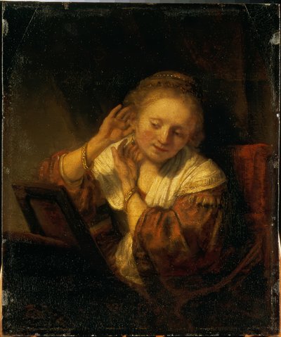 Kendini küpelerle süsleyen genç kadın by Rembrandt van Rijn