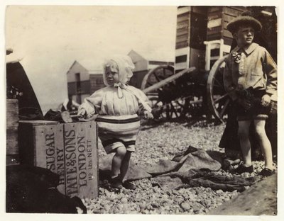 Banyo makinelerinin yanında iki çocuk, c 1895, Sahilde bir grup banyo makinesinin arasında duran iki çocuğun enstantane fotoğrafı by Unbekannt
